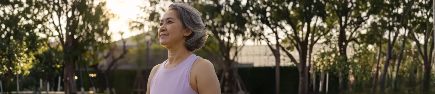 Person standing outside in workout clothes with hopeful expression