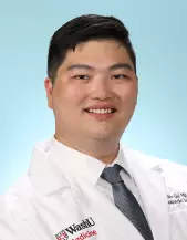 Photo of Alex Gu, MD, in white lab coat